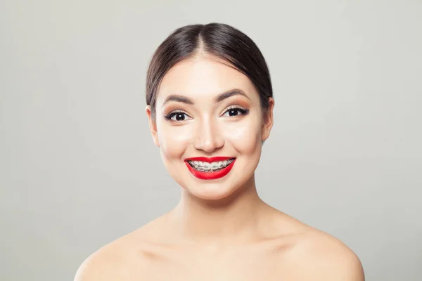 Atractiva morena con tirantes sonriendo sobre fondo blanco —  Fotos de Stock