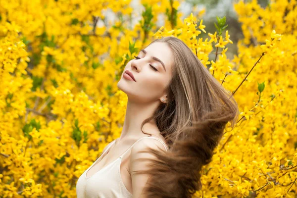 Mujer joven perfecta con un peinado saludable sobre fondo floral —  Fotos de Stock