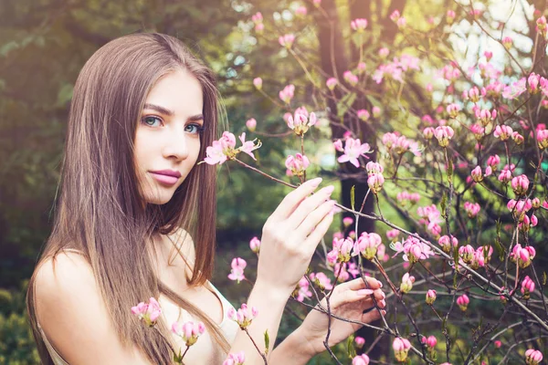 Mulher bonita cheirando flores ao ar livre — Fotografia de Stock