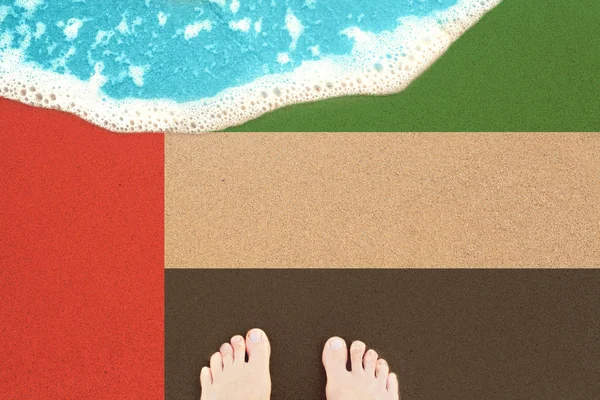 Πόδια στη θάλασσα άμμο και σέρφινγκ με σημαία ΗΑΕ. Διακοπές στην παραλία του ωκεανού — Φωτογραφία Αρχείου