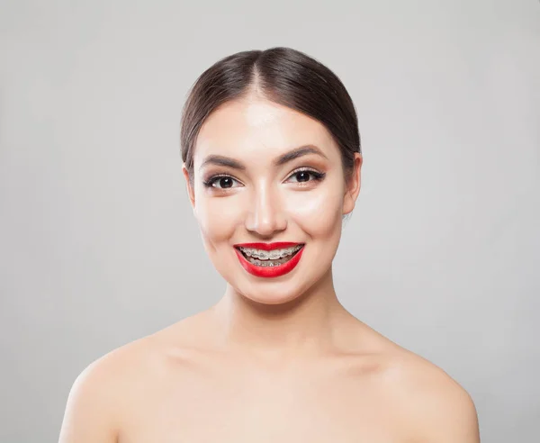 Mulher sorridente em aparelho no fundo branco — Fotografia de Stock