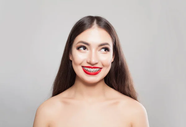 Mujer bonita con frenillos sonriendo en blanco —  Fotos de Stock