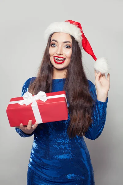 Beautiful Santa woman in braces holding Christmas gift — Stock Photo, Image