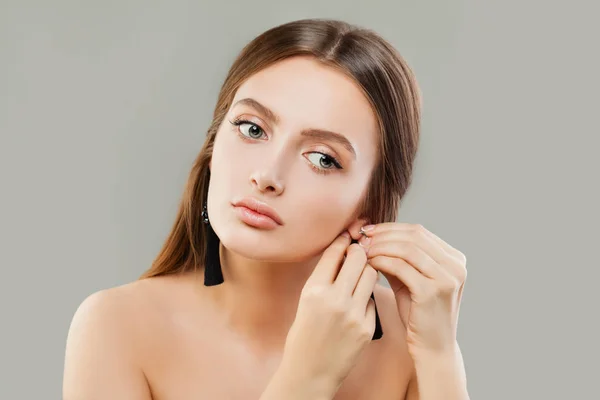 Hermosa mujer puting en pendientes de joyería — Foto de Stock