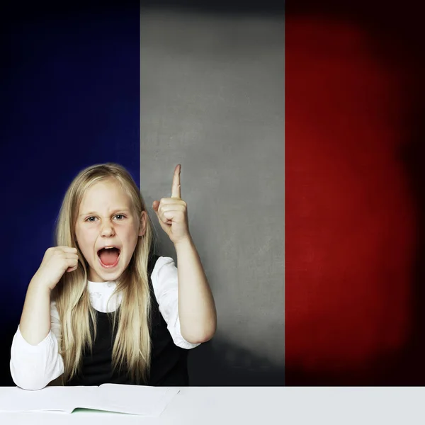 Pelajari konsep bahasa Perancis. Anak gadis bahagia menunjuk ke atas — Stok Foto