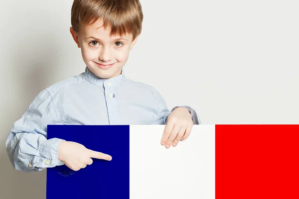 Niño feliz sosteniendo la bandera de Franch en blanco vacío Fotos De Stock Sin Royalties Gratis