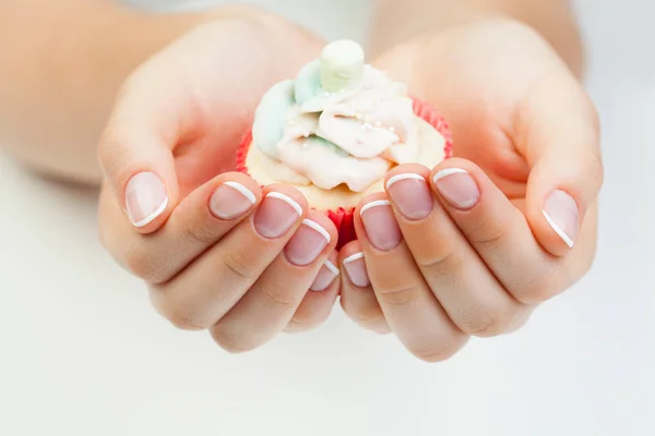 Manicura de belleza. Manos de mujer con clavos sosteniendo puncake — Foto de Stock