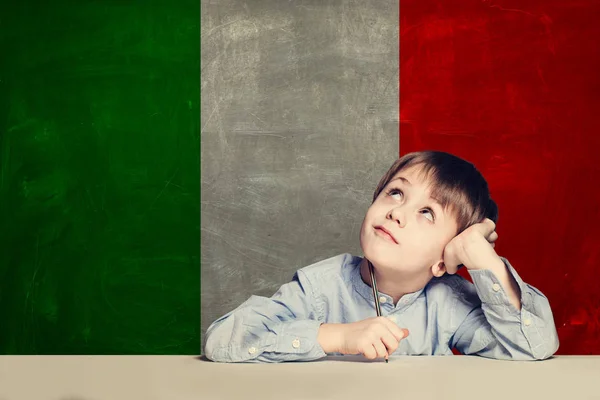 Tänkande barn pojke elev mot Italien flagga bakgrund. — Stockfoto