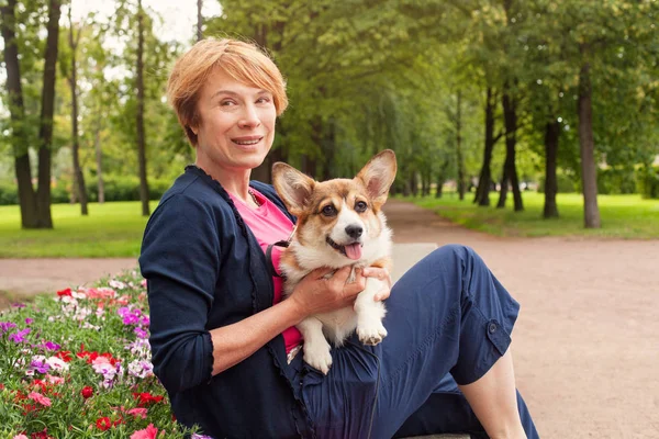 Senior Kvinna med sin söta vita hunden utomhus i sommarpark — Stockfoto