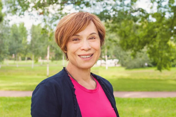 Retrato de cerca de una mujer mayor sana sonriendo al aire libre . —  Fotos de Stock