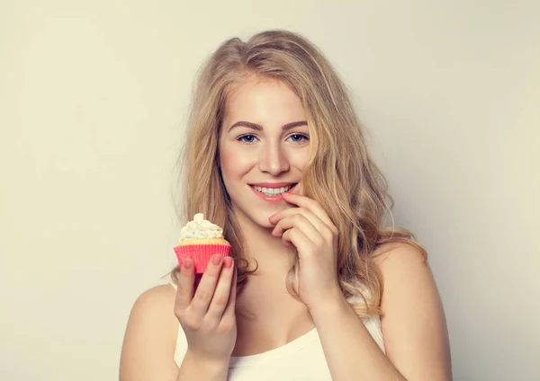 Lächelndes süßes Mädchen, das Kuchen in ihren Händen hält. — Stockfoto