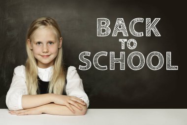 Chalkboard üzerinde düşünme gülümseyen sarışın çocuk kız. Okula geri dön