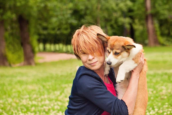 Yaz parkında yavru köpek hayvan ile mutlu olgun kadın — Stok fotoğraf