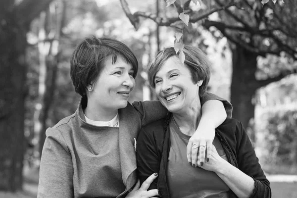 Gelukkige vrouwen knuffelen, wandelen in Park en rusten — Stockfoto