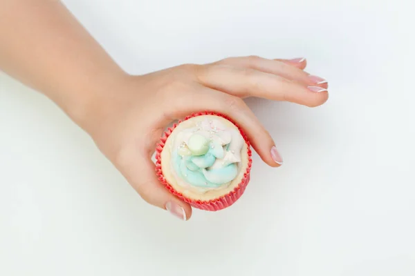 Beautiful manicured woman's hands holding cupcake on white — Stock Photo, Image