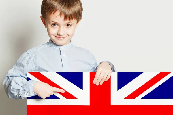 Niño feliz sosteniendo la bandera del Reino Unido en blanco Imagen De Stock