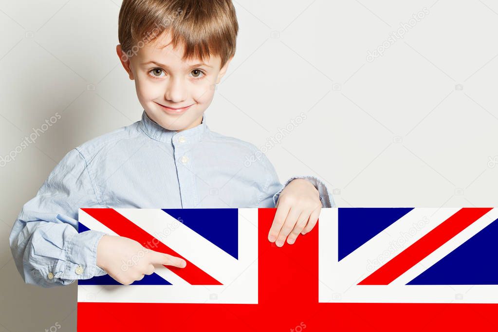 Happy child boy holding the UK flag banner on white 