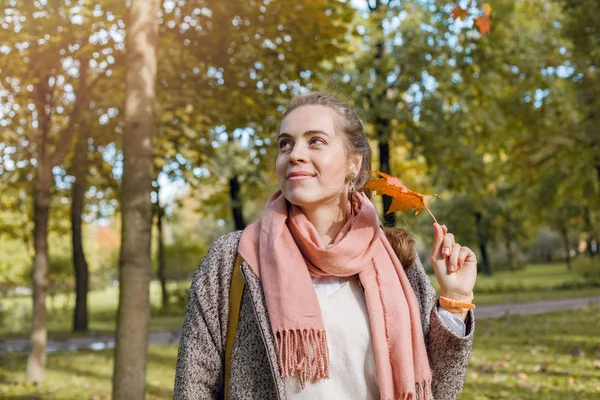 Mooie glimlachende jonge vrouw met gele esdoorn blad. — Stockfoto