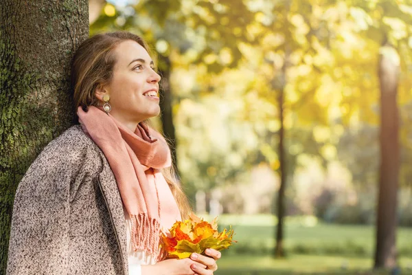Mooie herfst vrouw dromen en holding gele Maple Leaf — Stockfoto