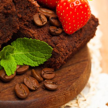 Yeşil yaprakları kahve taneli çikolatalı kek çilek