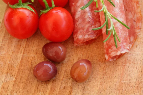 Nourriture gastronomique - salami, olives, tomates et herbes de romarin gros plan — Photo
