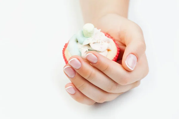 French manicured nails on female hand and cupcake on white — Stock Photo, Image