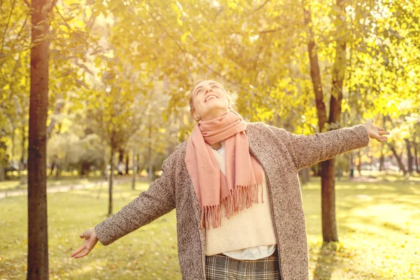 Hermosa mujer de otoño sosteniendo hoja de arce amarillo al aire libre . — Foto de Stock