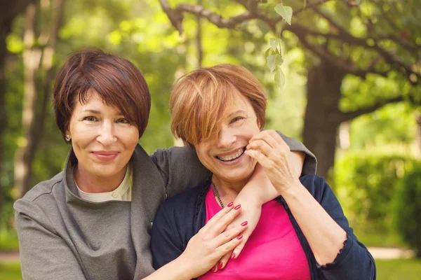 Two happy women walking in summer park, portrait — Stock Photo, Image