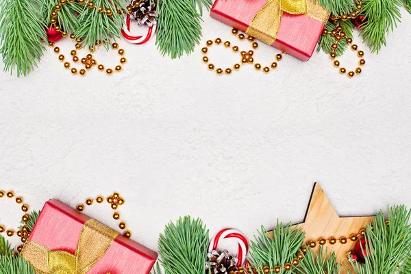 Σύνορα σύνθεσης Χριστουγεννιάτικης κάρτας. Χρυσό στεφάνι, πράσινα Χριστουγεννιάτικα Ελάτα, κόκκινα μούρα, δώρο και μπαάδες σε λευκό στόκο γύψο υφή φόντο. Χριστούγεννα περίγραμμα, κορυφή θέα επίπεδη με χώρο αντιγραφής — Φωτογραφία Αρχείου