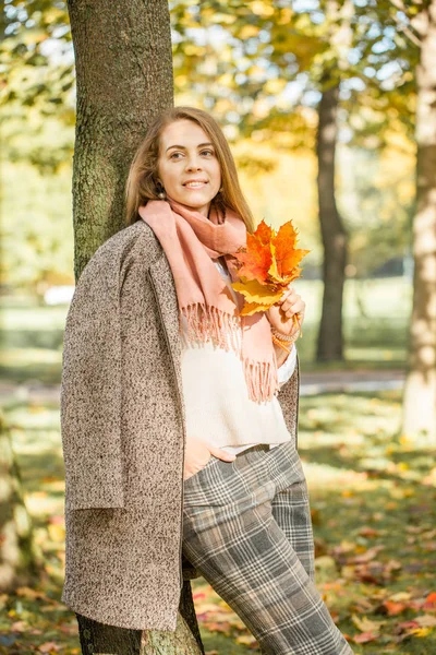 Güzel kadın rüyalar ve sonbahar sarı akçaağaç yaprağı tutan 
