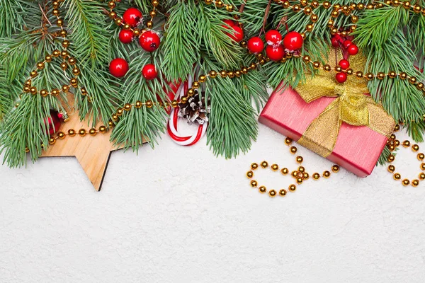 Branche de sapin de Noël, baies de houx rouge, cadeau, bonbons et boule — Photo