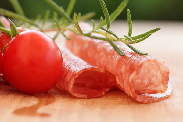 Gourmet food - salami, tomatos and rosemary herbs closeup — Stock Photo, Image