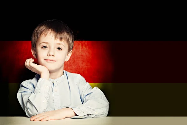 Pensando niño estudiante contra la bandera de Alemania fondo . —  Fotos de Stock