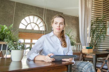 Genç akıllı kadın dizüstü gadget ile oturan ve çalışma