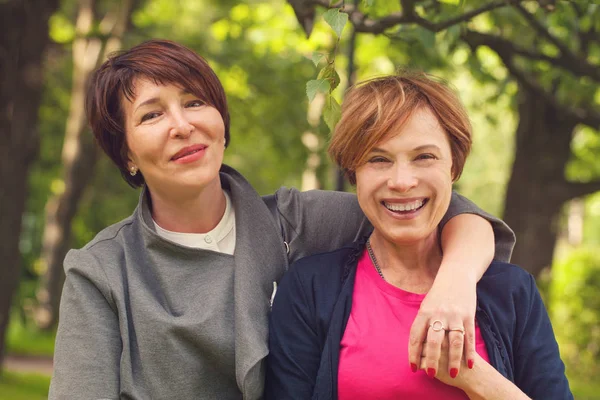 Дві щасливі жінки, що ходять в літньому парку, портрет — стокове фото