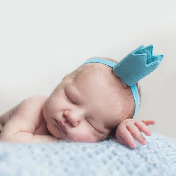Mooie pasgeboren baby meisje in blauwe kroon, close-up portret — Stockfoto
