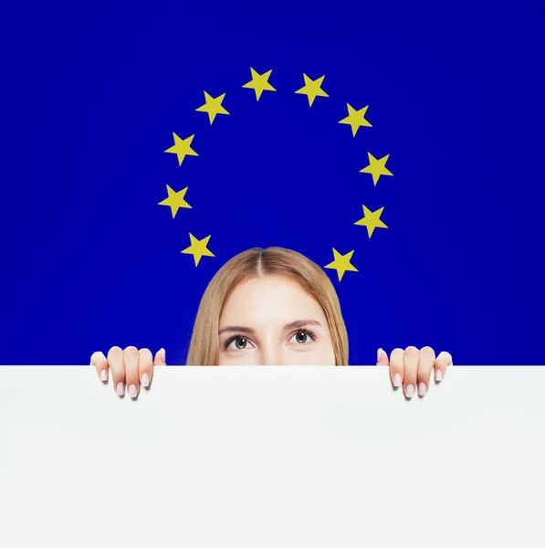 Mulher feliz mostrando fundo branco contra o fundo da bandeira da UE — Fotografia de Stock