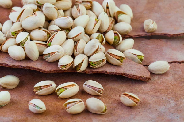 Tasty pistachio nuts on tree rind background — Stock Photo, Image