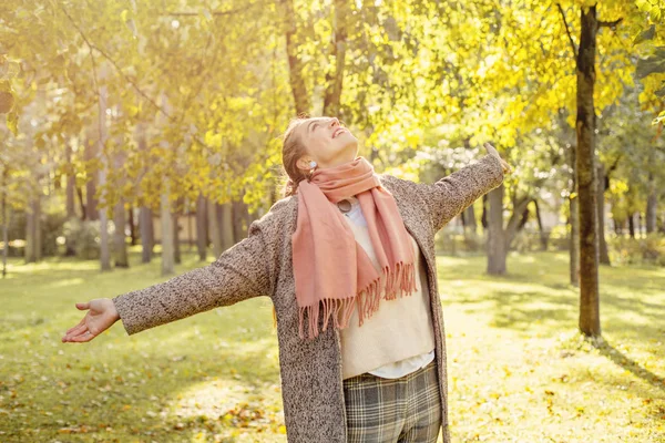 Hermosa mujer de otoño sosteniendo hoja de arce amarillo al aire libre . — Foto de Stock