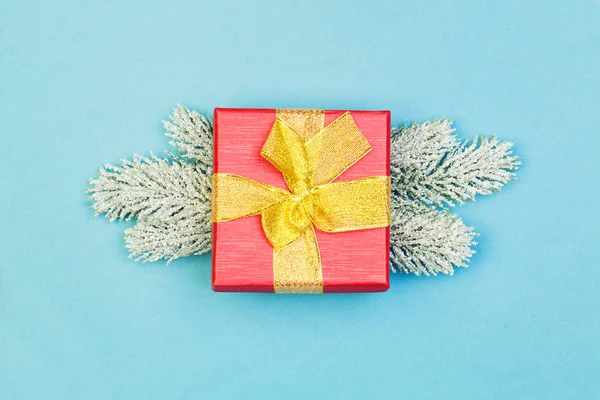 Regalo de Navidad y rama de abeto verde sobre fondo azul — Foto de Stock