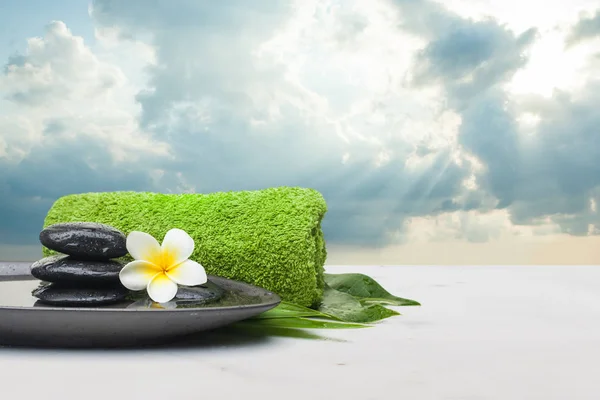 Spa set with stones. towel and floweron dark plate — Stock Photo, Image