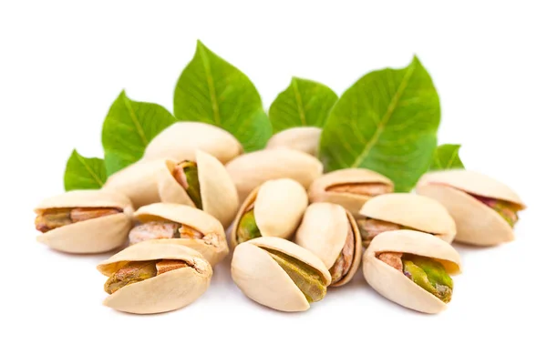 A few Pistachio nuts with leaves on white background — Stock Photo, Image