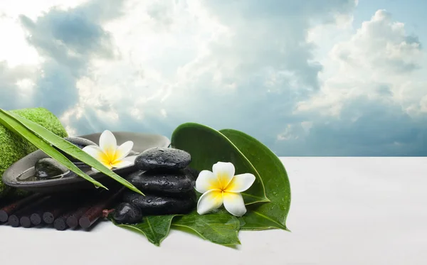 Spa tropical leaves and flowers and black stones for healthy therapy