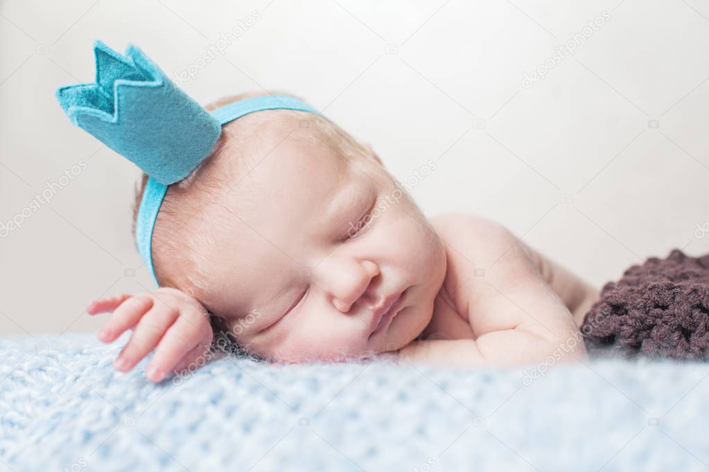 Newborn baby sleeping on blue woolen blanket
