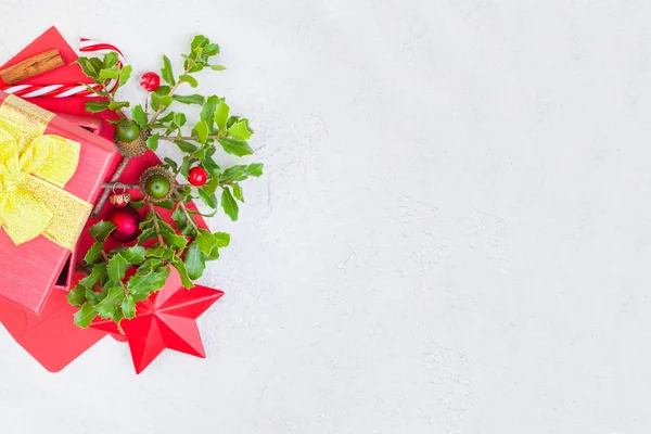 圣诞礼物和白色石膏背景的冬青浆果 — 图库照片