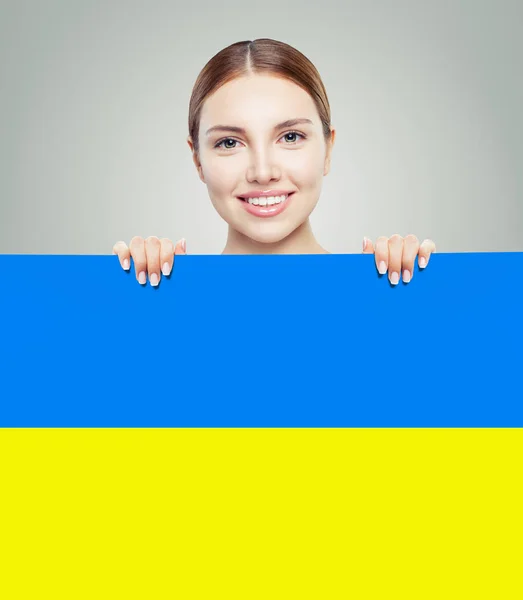 Porträtt av leende kvinna med ukrainska flagga — Stockfoto