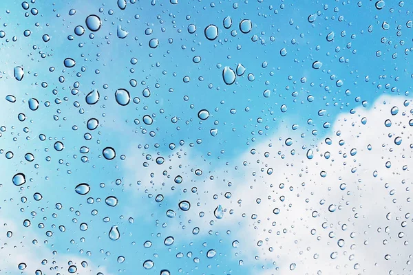 水滴在蓝天蓝云背景的玻璃杯上. — 图库照片