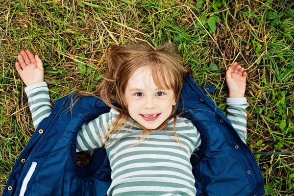 Bovenaanzicht portret van een mooi kind meisje in blauwe jas ontspannen — Stockfoto