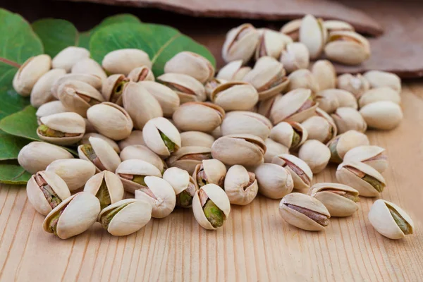 Tasty  pistachio nuts on wooden table background — Stock Photo, Image