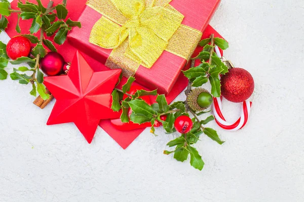 Weihnachtskomposition. Weihnachtsgeschenkschachtel, Stechpalmenbeeren und rote Deko — Stockfoto